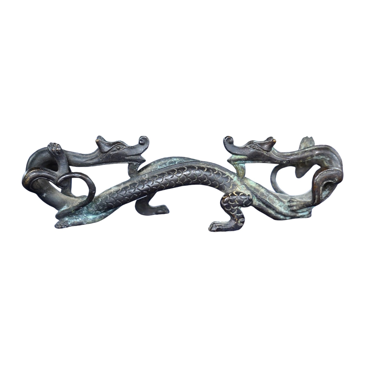 A Chinese bronze brush rest modelled as two dragons, 17cm wide. Condition - good